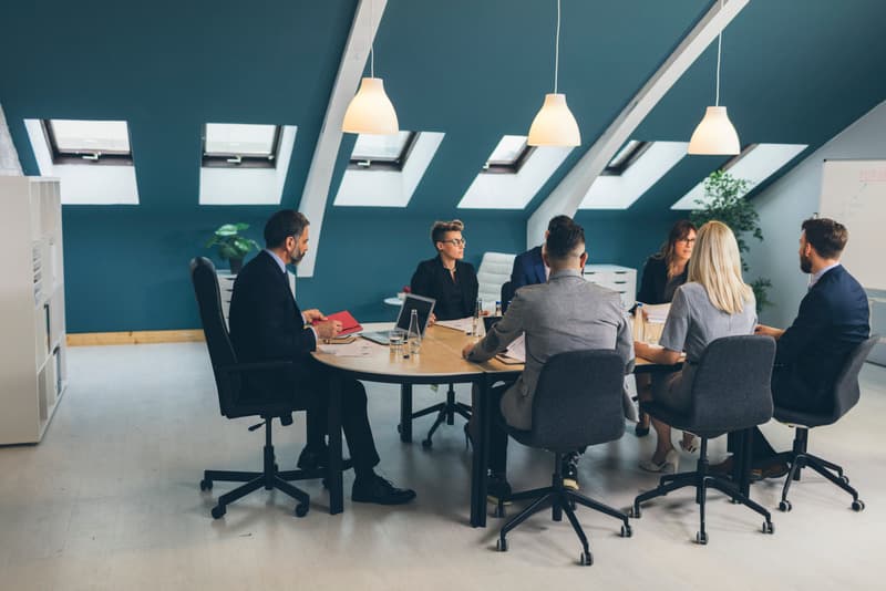Foto Quem Somos, colaboradores sentados em uma mesa